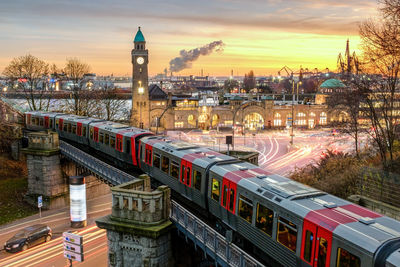 High angle view of train in city against sky at sunset