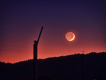 Scenic view of silhouette moon against sky at sunset