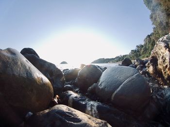 Rocks on beach against clear sky