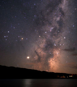 Scenic view of silhouette mountain against sky at night