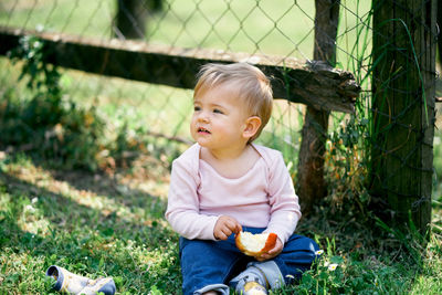 Cute girl looking away sitting outdoors