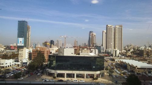 View of cityscape against cloudy sky