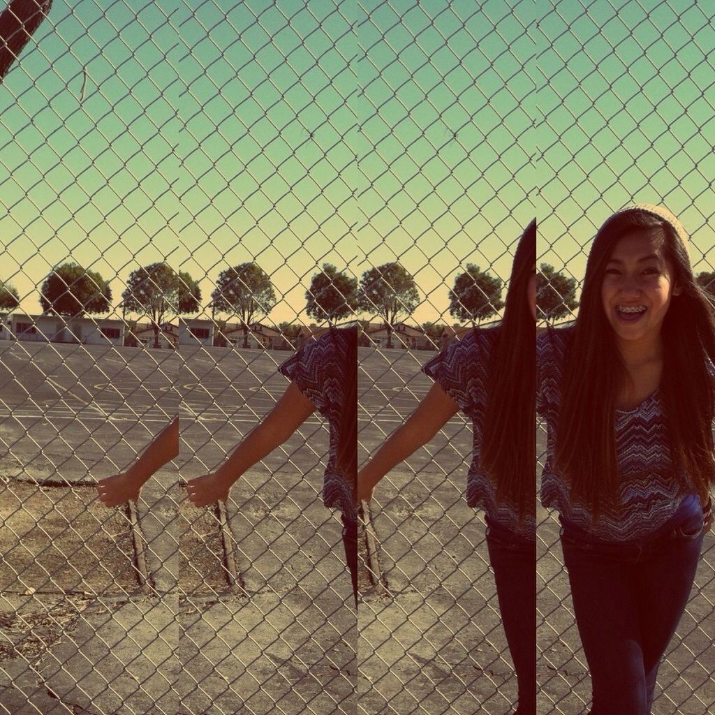 lifestyles, leisure activity, standing, casual clothing, young adult, protection, sky, person, young women, front view, outdoors, day, portrait, safety, looking at camera, fence, built structure