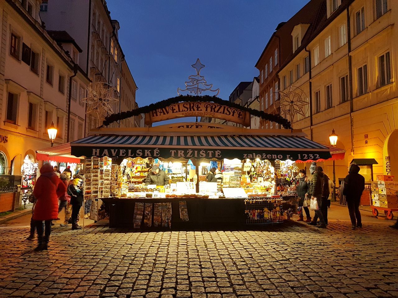 building exterior, architecture, built structure, real people, illuminated, men, large group of people, night, outdoors, leisure activity, city, market, women, lifestyles, full length, standing, sky, people