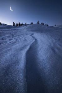 Shapes created by the wind in the snow in a blue morning in cortina d'ampezzo, in the dolomites. 