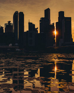 Modern buildings in city against sky during sunset