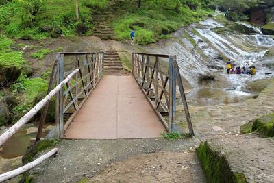 High angle view of footbridge over footpath amidst trees