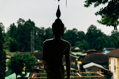 Rear view of man statue outside temple