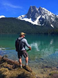 Full length of young man standing on rock by lake