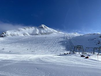 Snow covered mountain against blue sky