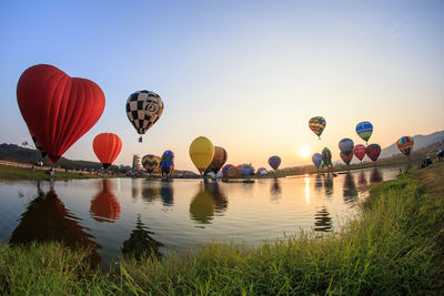Hot air balloons flying over water against sky