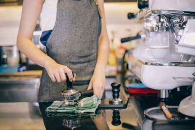 Barista using portafilter in coffee shop