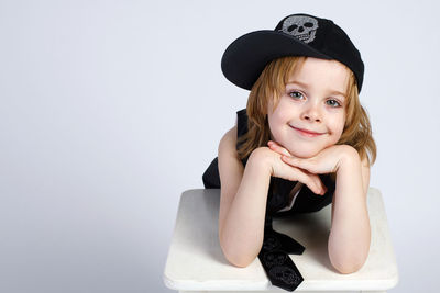 Portrait of smiling girl sitting against white background