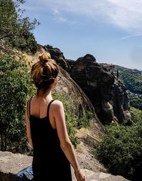 Rear view of woman standing on rock