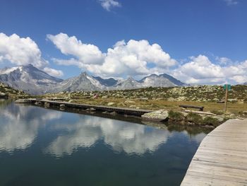 Scenic view of lake and mountains against blue sky