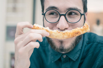 Close-up of smiling of man having pizza