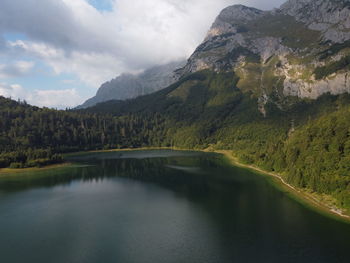 Scenic view of lake by mountains against sky