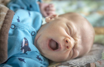 Close-up of baby sleeping on bed