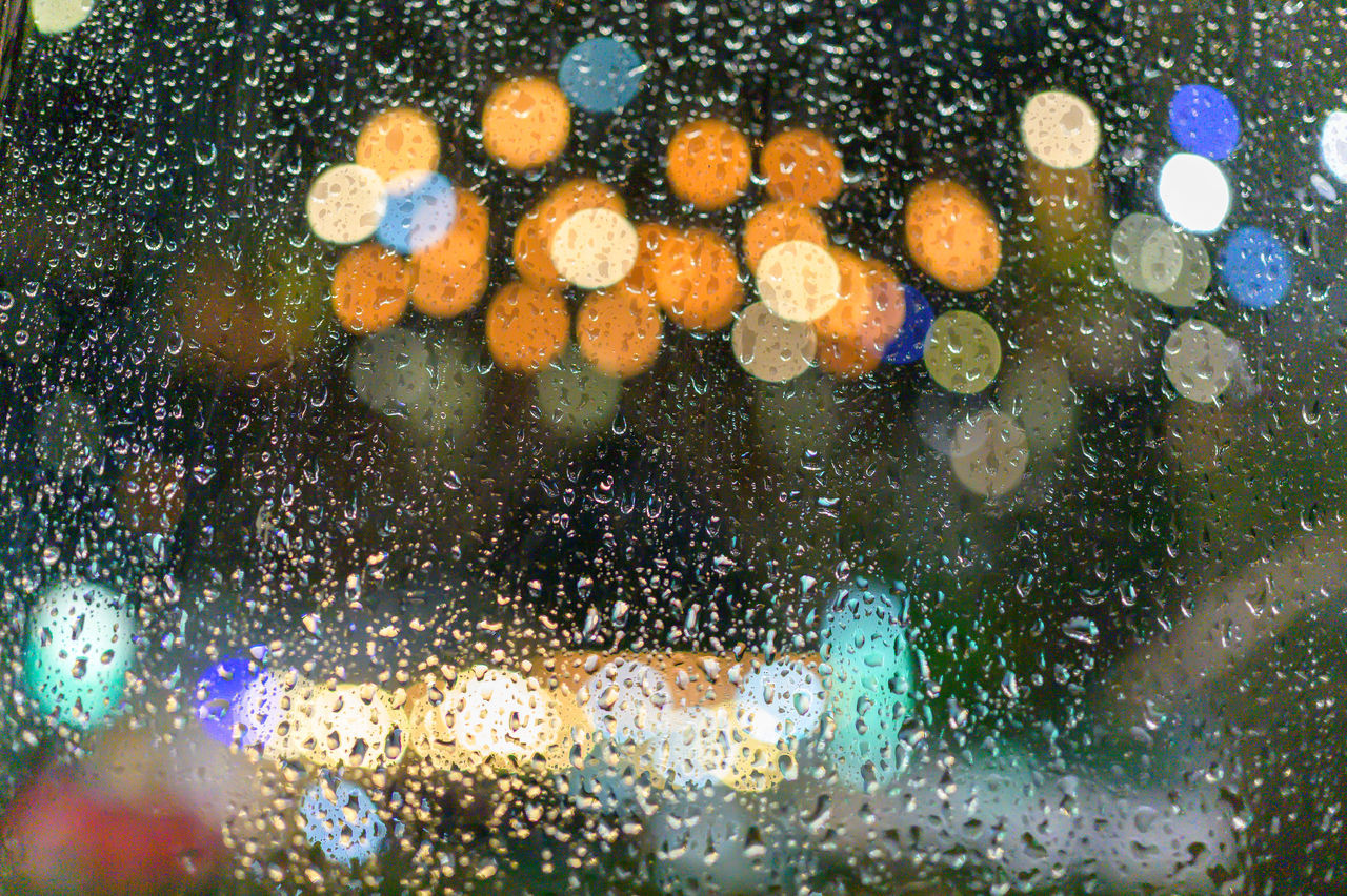 CLOSE-UP OF RAINDROPS ON GLASS WINDOW