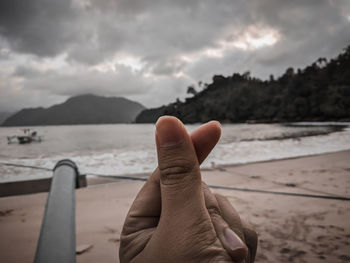 Midsection of person against sea against sky