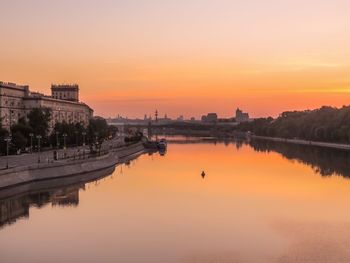 Reflection of buildings in lake during sunset