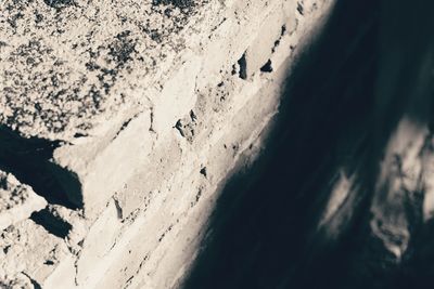 Close-up of sand on snow against sky