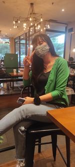 Woman sitting on chair in restaurant