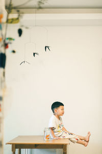 Boy looking away while sitting on toy