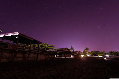 Illuminated buildings against sky at night