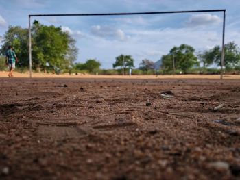 Surface level of dirt road against sky