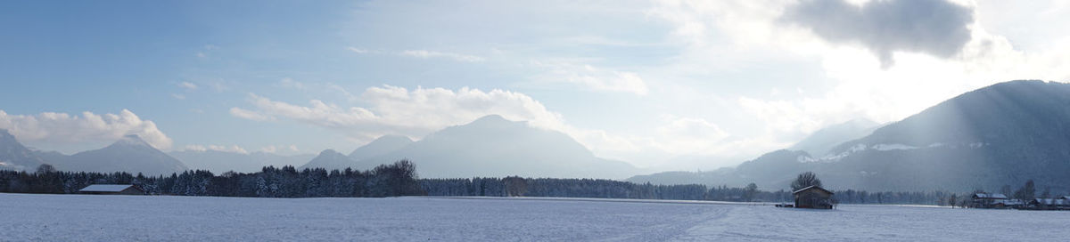 Panoramic view of snow covered mountains against sky