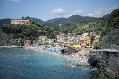 Buildings by sea against sky