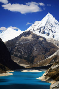 Scenic view of lake and snowcapped mountains against sky 