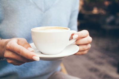 Close-up of hand holding coffee cup