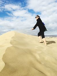 Full length of woman on beach against sky