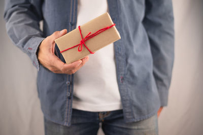 Midsection of man holding mobile phone