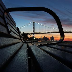 Bridge in city against sky during sunset