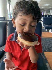 Cute boy eating food at airport terminal