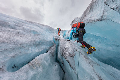 People climbing on frozen mountain