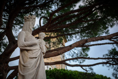 Low angle view of statue against trees