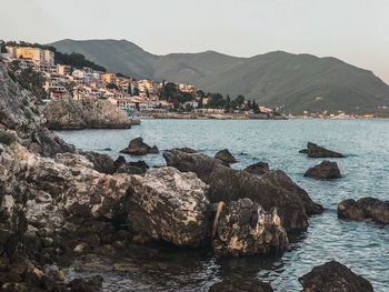 Scenic view of sea by townscape against clear sky