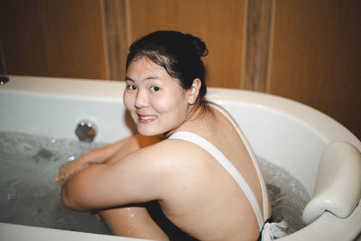 Portrait of shirtless baby boy in bathtub at home