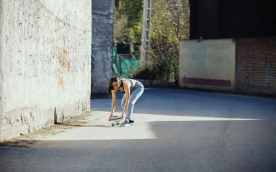 Full length of man skateboarding on road in city