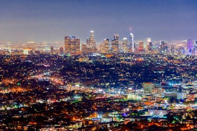 Illuminated cityscape against sky at night