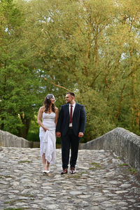 Rear view of couple walking on footpath