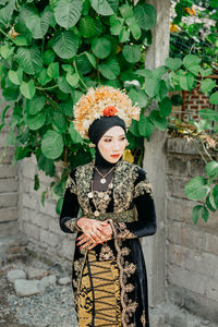 Portrait of woman standing against plants