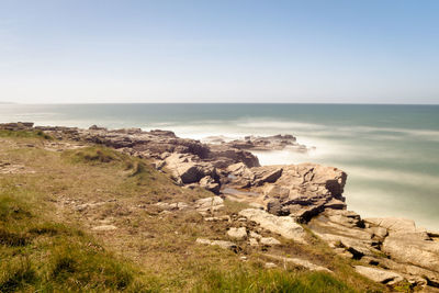 Scenic view of rocks on beach against sky