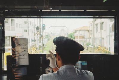 Rear view of man working at window