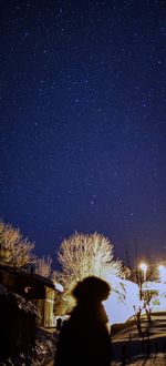Rear view of man against illuminated star field at night