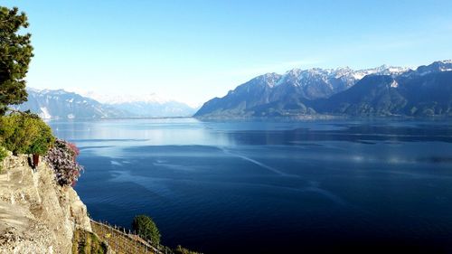 Scenic view of sea and mountains against blue sky